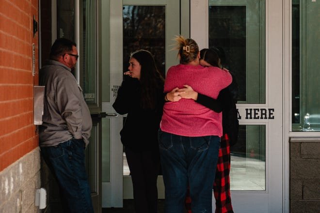 Parents and students embrace Tuesday, Nov. 14 outside the vestibule at Tuscarawas Valley Middle/High School in Zoarville, Ohio.